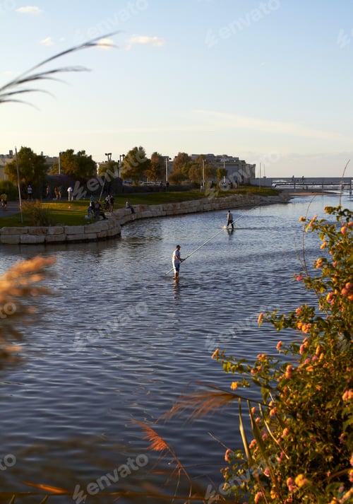 Preview: Angler catches fish in the river at sunset against the blue