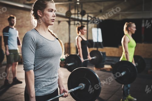 Preview: Woman in class doing dead lift barbell exercise