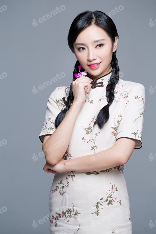 Preview: Young beautiful woman in traditional cheongsam with orchid
