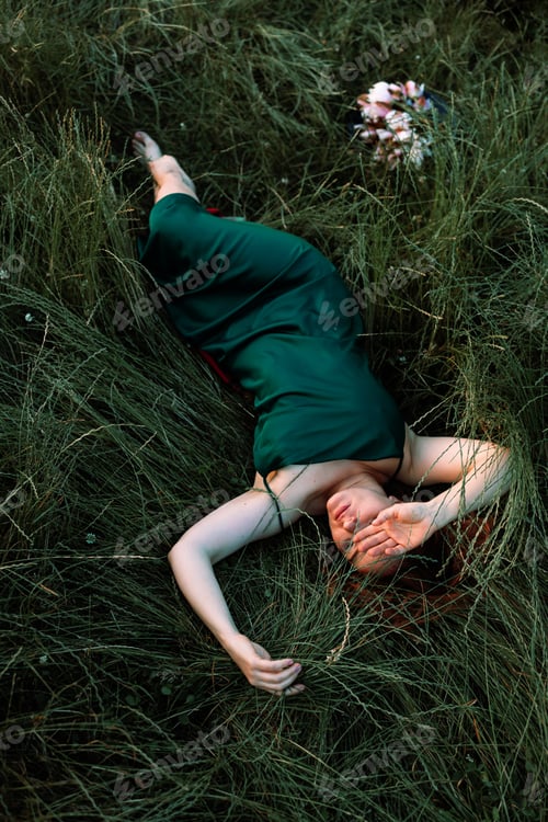 Preview: Summer lifestyle portrait of beautiful young woman holding water lily flowers. sitting in the field
