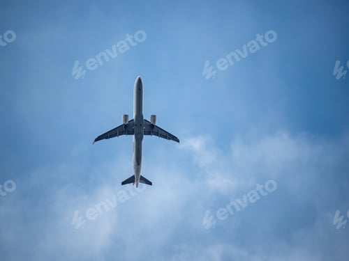 Preview: Scenic view of an airplane flying in the blue sky