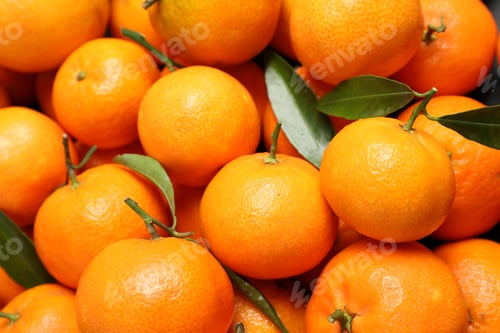 Preview: Fresh ripe tangerines with leaves as background, above view. Citrus fruit
