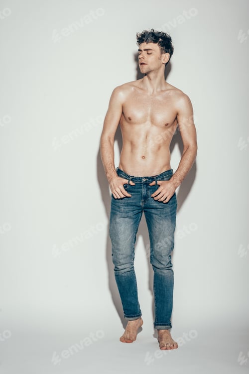 Preview: sexy shirtless handsome man in jeans posing on grey