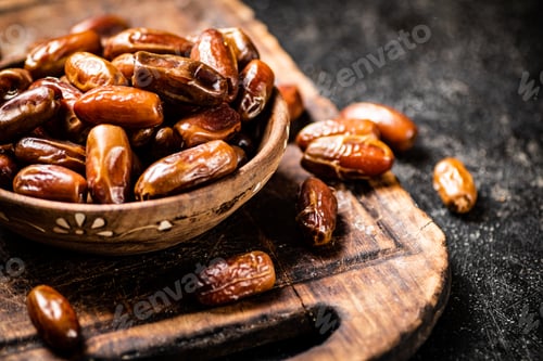 Preview: Dates in a plate on a cutting board.