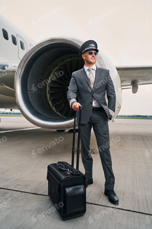 Preview: Smiling airman with his baggage at the aerodrome