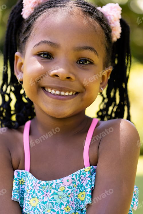 Preview: Closeup portrait of smiling african american cute girl with dreadlocks looking at camera