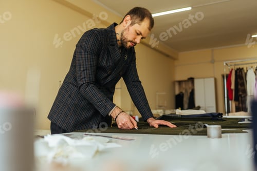 Preview: Tailor at work, drawing line on fabric with chalk