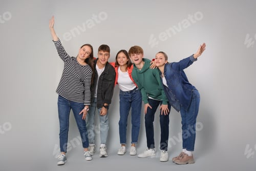 Preview: Group of happy teenagers on light grey background