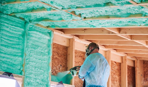 Preview: Worker spraying polyurethane foam for insulating wooden frame house.