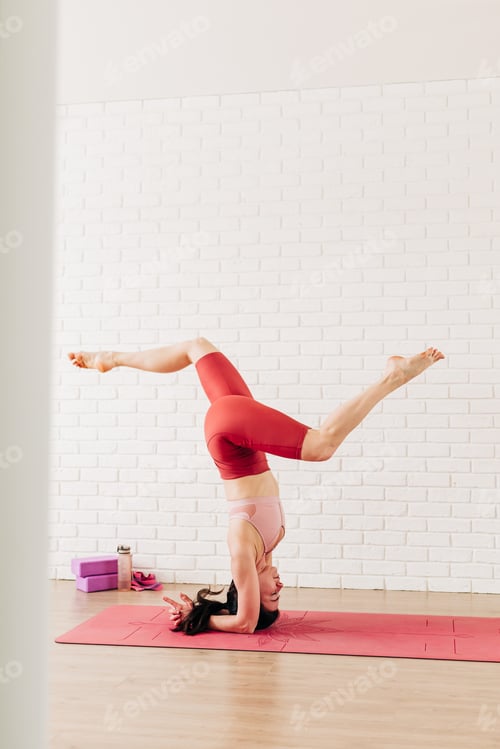 Preview: Young woman doing yoga practice at home indoors. Room with white walls and big mirrors
