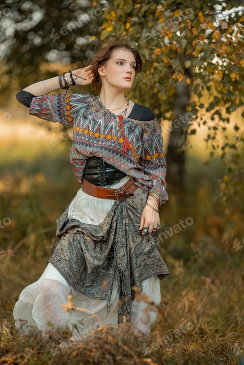 Preview: Young woman in boho style clothes posing in autumn forest