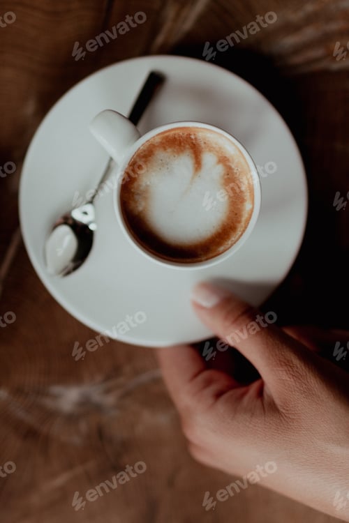 Preview: The woman is serving espresso macchiato on the dark brown wooden table