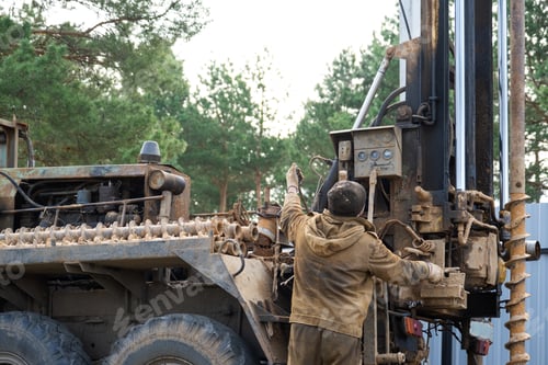 Preview: Team of workers with drilling rig on car are drilling artesian well for water in ground