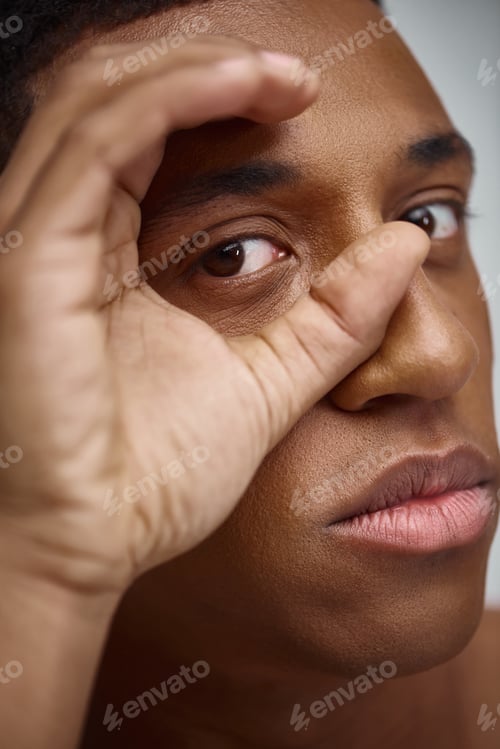 Preview: close up of handsome appealing african american man with hand in front of face, fashion concept