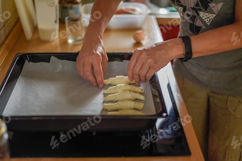 Preview: Selective focus shot of a female putting pastry on an oven pan