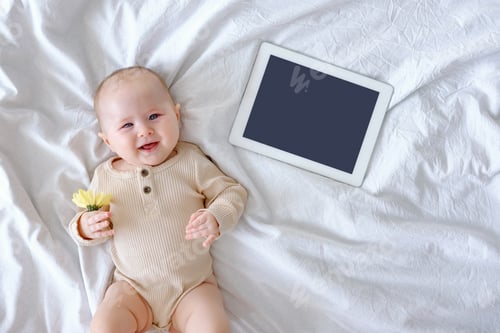 Preview: A cute baby laying on a white linen holding a chrysanthemum flower. International woman’s day card