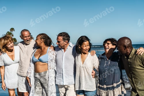 Preview: Happy multiracial senior friends having fun on the beach during summer holidays