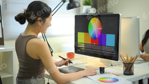Preview: Graphic designer woman working on creative desk computer while using graphic tablet