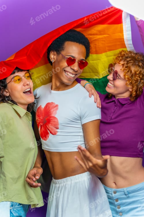 Preview: Gay man and lesbian women dancing covered by rainbow flag