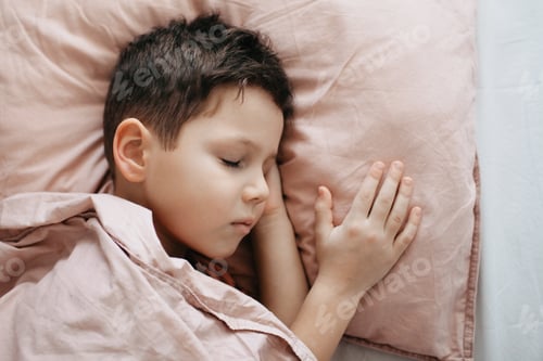 Preview: A 5-year-old boy sleeps on a large pillow covered with a blanket
