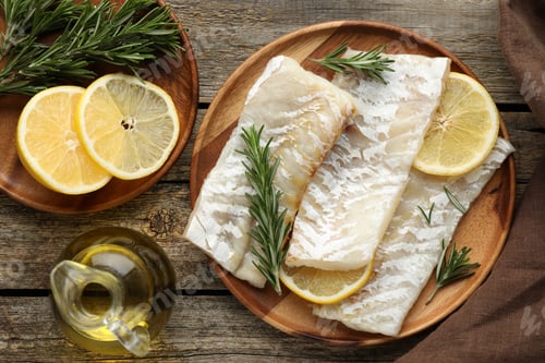 Preview: Fresh raw cod fillets with rosemary, lemon and oil on wooden table, flat lay