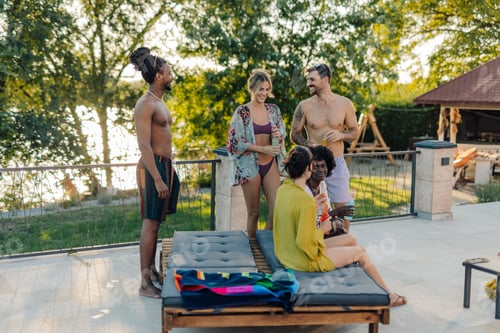 Preview: Friends enjoying drinks at a luxurious lakeside summer pool party