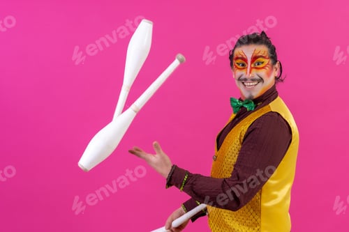 Preview: Cheerful circus performer skillfully juggling a number of clubs isolated on pink background