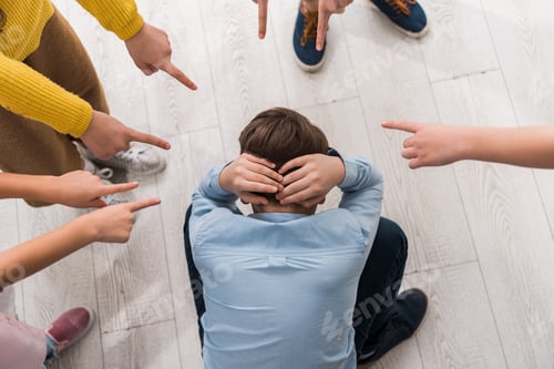 Preview: top view of cruel schoolkids pointing with fingers at bullied classmate