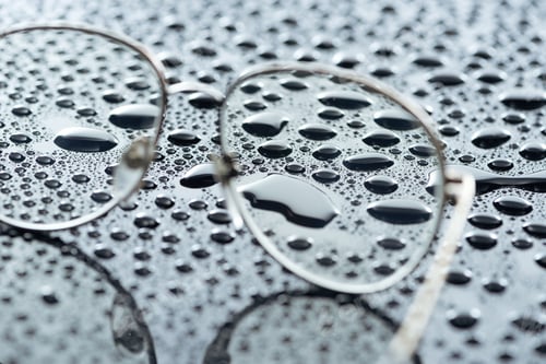 Preview: close up view of eyeglasses and water drops on grey backdrop