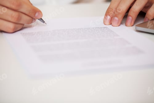 Preview: Man signs a contract at a desk in a company office