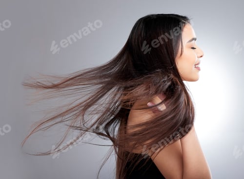Preview: Studio shot of an attractive young woman posing against a grey background
