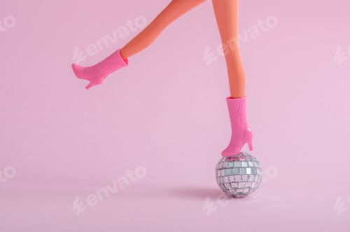 Preview: Doll feet on a small disco ball on a pink background