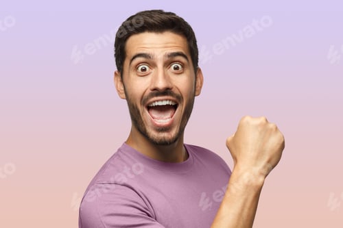 Preview: Young man in casual purple t-shirt screaming while his team win, raised fist in victory gesture