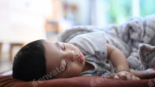 Preview: Close up view of peaceful baby sleeping on bed in a bright room.