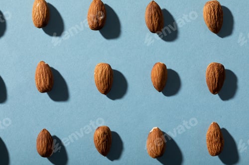 Preview: Full frame shot of almonds arranged on blue background with copy space