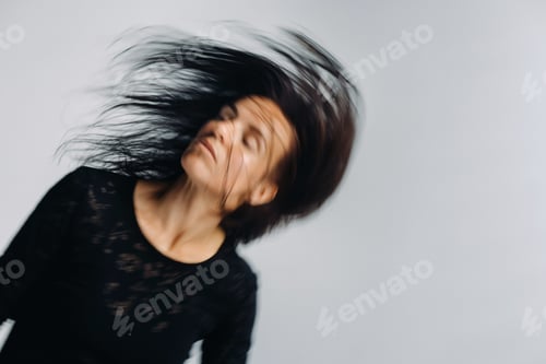 Preview: A girl in a black dress moves in a dance on a gray background. Dynamic dance