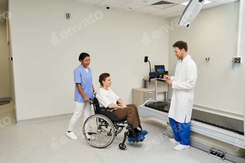 Preview: Medical professionals assist a patient in a wheelchair for an MRI procedure