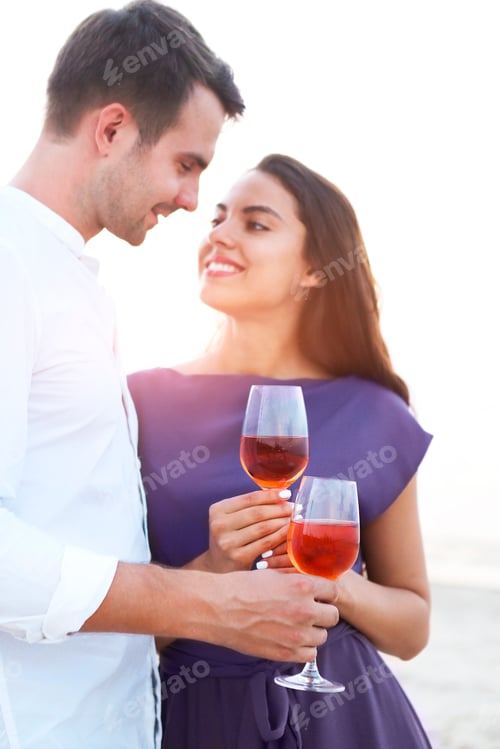 Preview: Affectionate Young Couple Toasting with Wine at Sunset