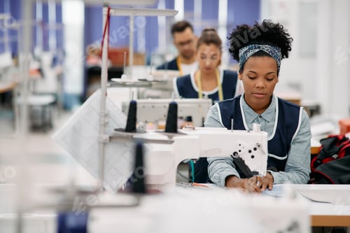Preview: African American dressmaker working at production line in a factory.