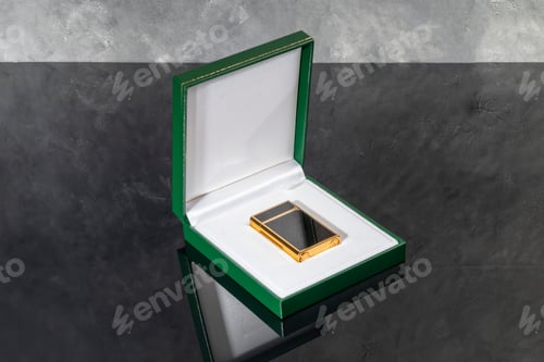 Preview: High quality lighter in a box on a dark background. Office interior.