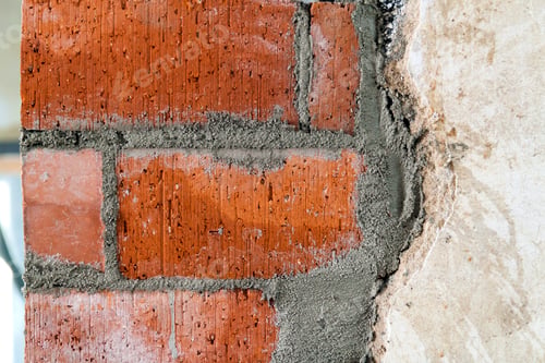 Preview: Close up of bricklaying industrial installing bricks on construction site wall