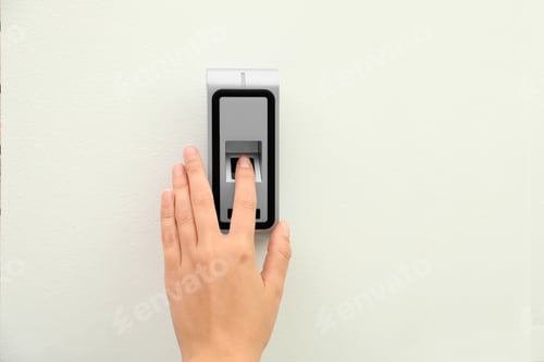 Preview: Young woman scanning fingerprint on alarm system indoors