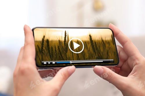 Preview: Woman watching video on mobile phone at home, closeup