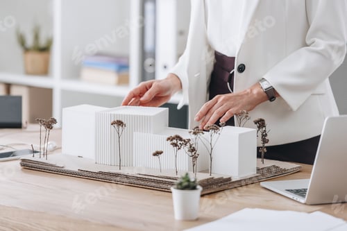 Preview: cropped view of female architect with house model at workspace