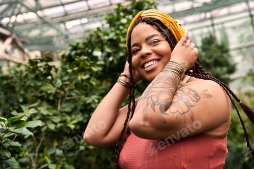 Preview: Sunlit moments in a vibrant greenhouse with a joyful woman in a stylish dress
