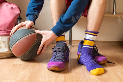 Visualização: jogador de basquete no vestiário no banco segurando a bola f