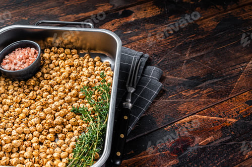 Preview: Vegetarin snack fried spicy chickpeas in a kitchen tray. Wooden background. Top view. Copy space