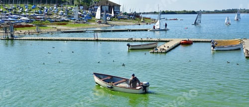 Preview: several boats and motorboats are docked in the water near a harbor