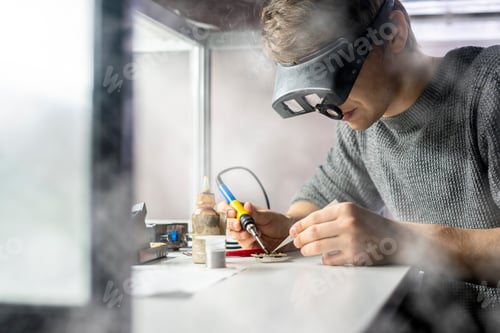 Preview: young scientist soldering microcircuit. science b