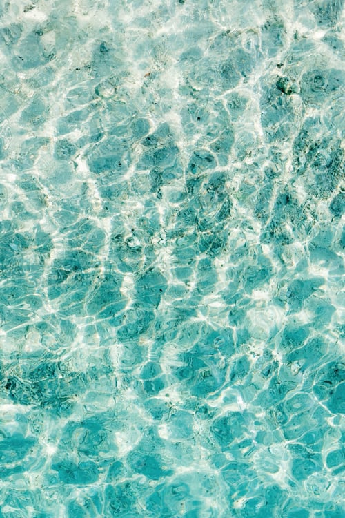 Preview: Clear turquoise water reflecting sunlight creates beautiful patterns in a shallow beach